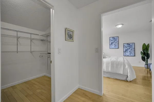 a view of a bedroom with wooden floor and hallway