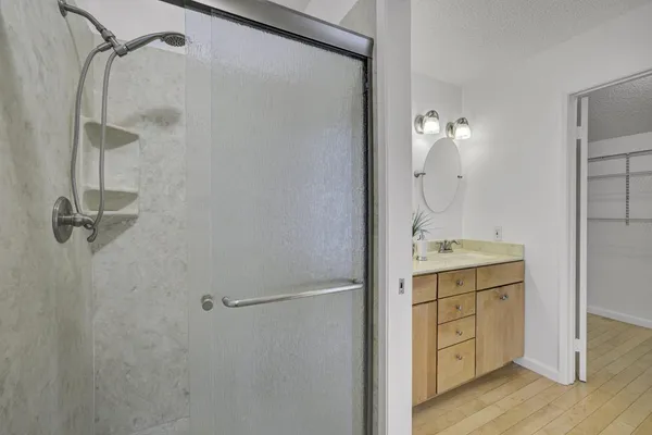 a bathroom with a shower sink and mirror