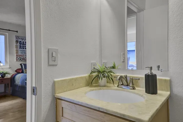 a bathroom with a granite countertop sink and a mirror