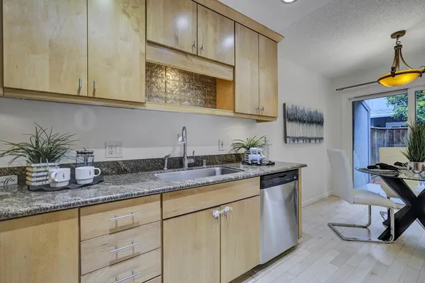 a kitchen with stainless steel appliances granite countertop a sink a stove and cabinets