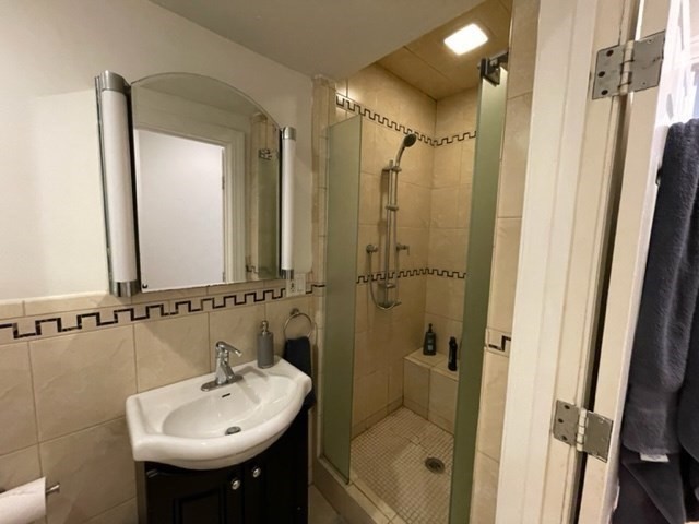 1793 Beacon Street, Unit 3 Brookline, MA 02445 - Photo 17 of 25 a bathroom with a sink a mirror a bathtub and shower