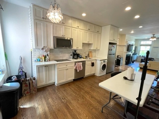 1793 Beacon Street, Unit 3 Brookline, MA 02445 - Photo 6 of 25 a kitchen with a sink a stove a refrigerator and chairs