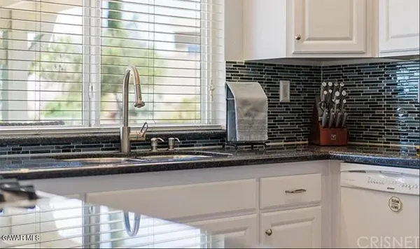 a kitchen with granite countertop white cabinets and a window