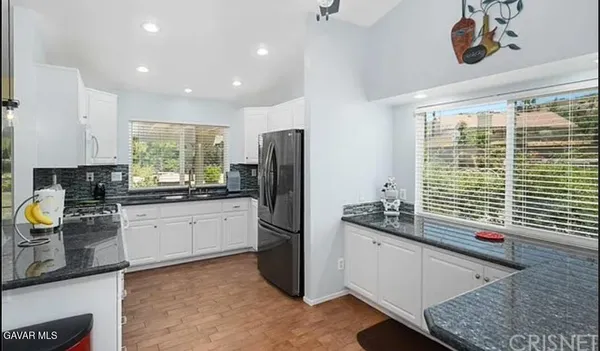 a kitchen with stainless steel appliances granite countertop a refrigerator and a sink