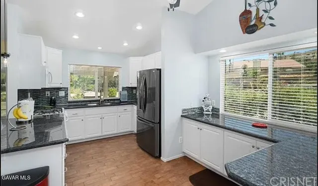 a kitchen with stainless steel appliances granite countertop a refrigerator and a sink