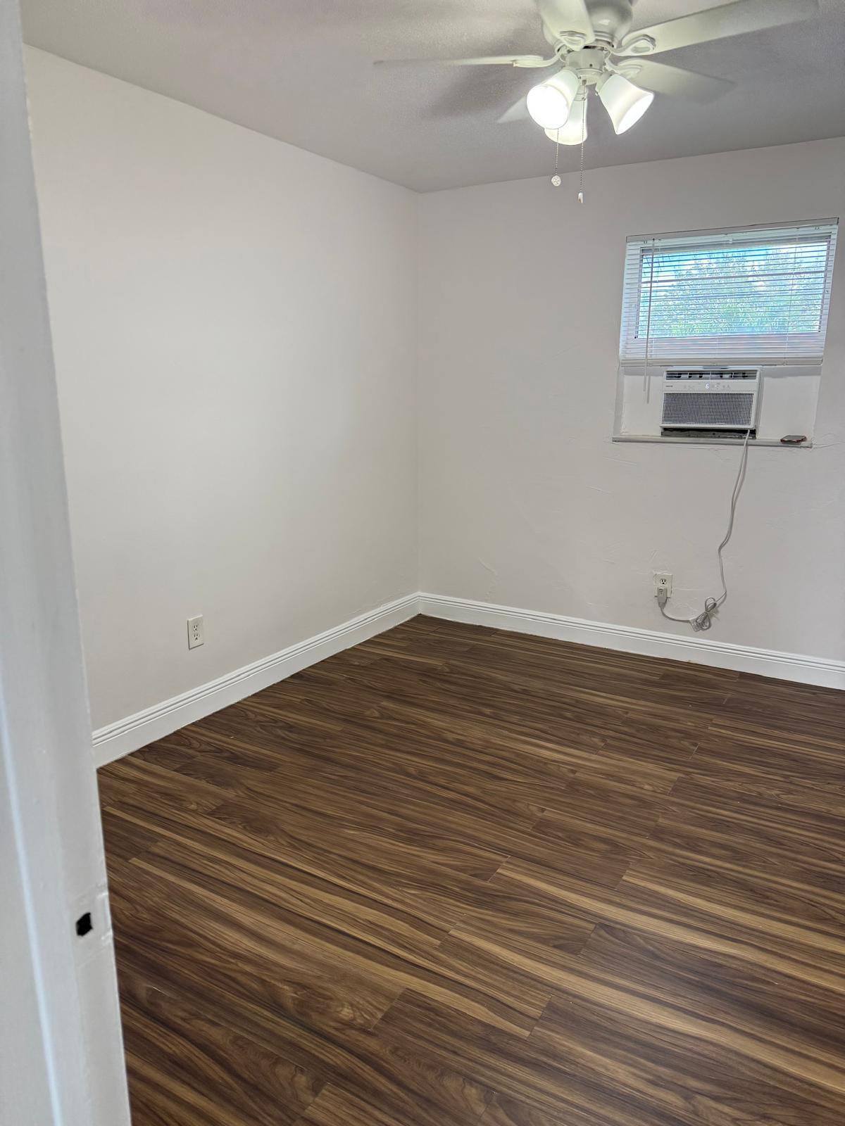 126 Cleveland Street, Unit 7 Lake Worth Beach, FL 33461 - Photo 13 of 24 a view of a room with wooden floor and chandelier
