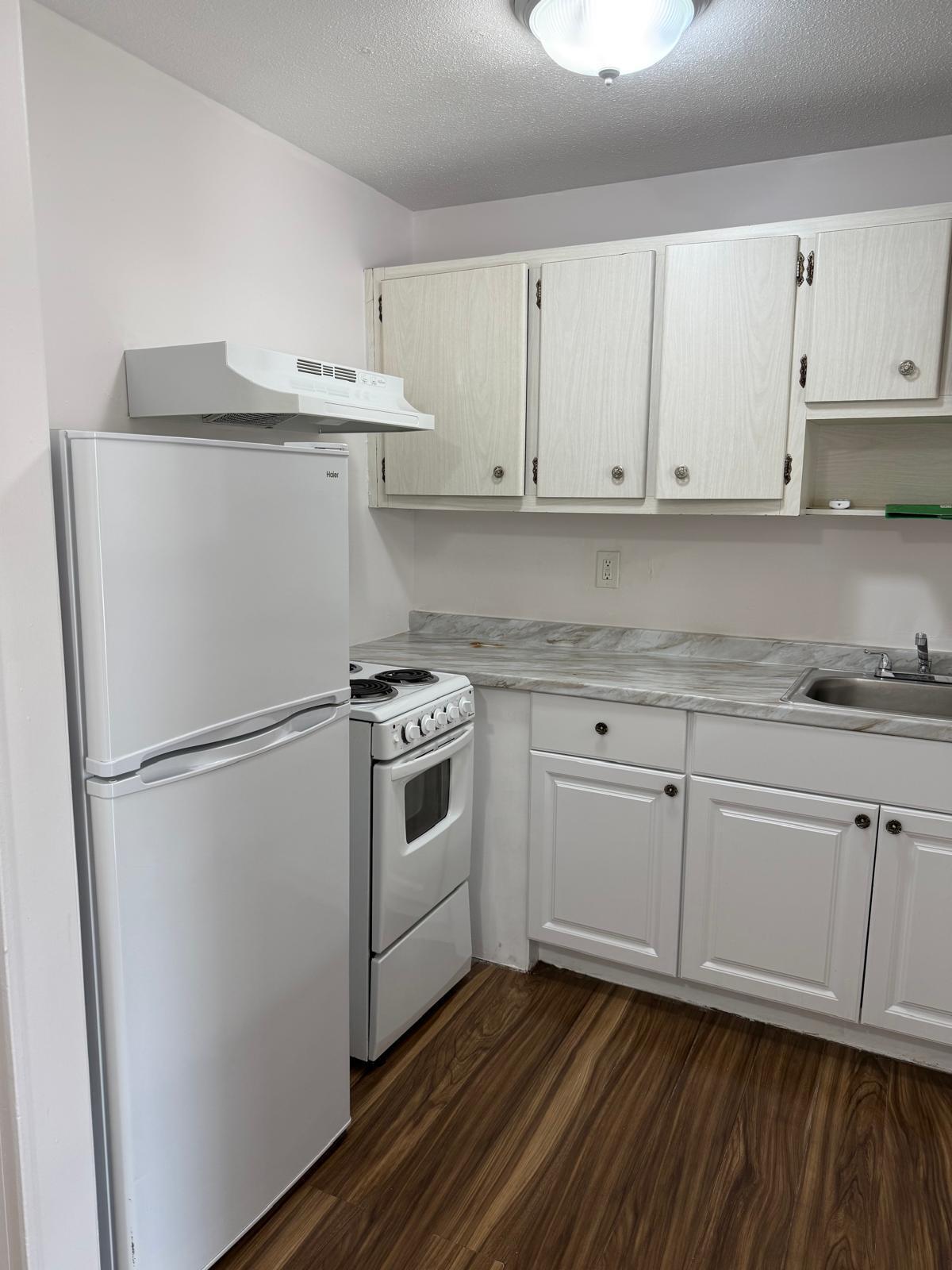 126 Cleveland Street, Unit 7 Lake Worth Beach, FL 33461 - Photo 4 of 24 a kitchen with white cabinets and white appliances