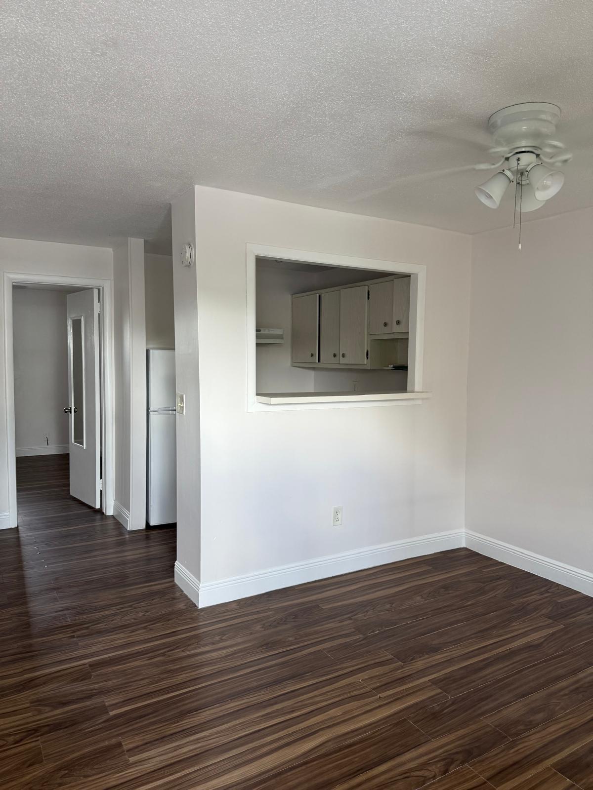 126 Cleveland Street, Unit 7 Lake Worth Beach, FL 33461 - Photo 7 of 24 a view of a room with wooden floor and a chandelier