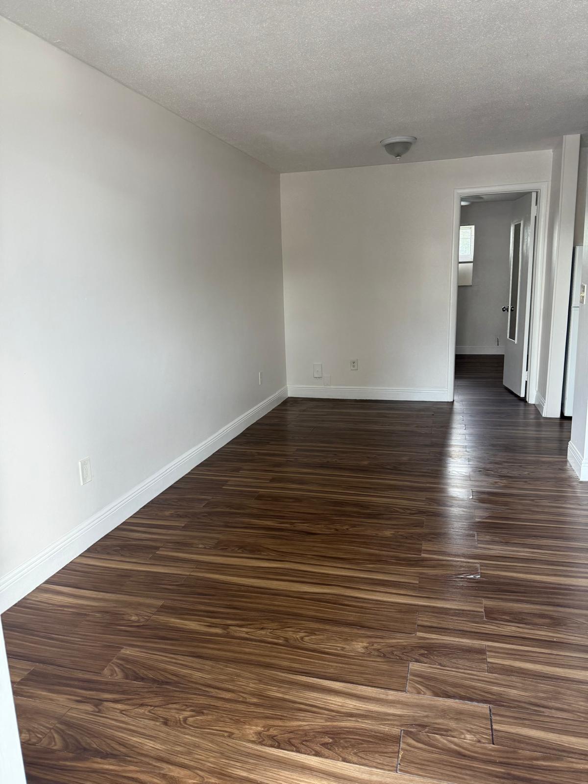 126 Cleveland Street, Unit 7 Lake Worth Beach, FL 33461 - Photo 9 of 24 a view of an empty room with wooden floor