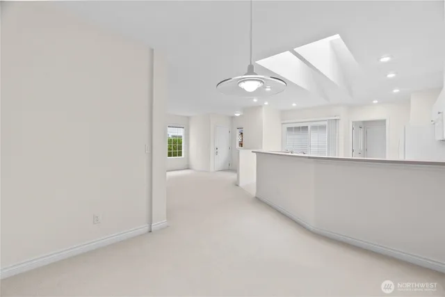 an empty room with a kitchen and a ceiling fan