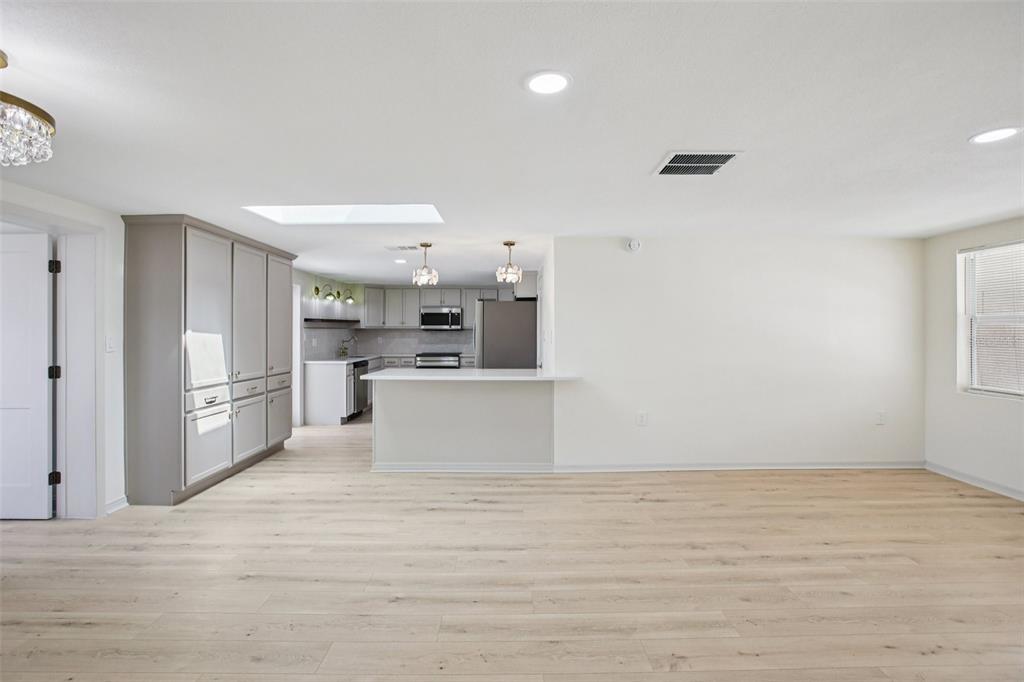 5753 10th Avenue New Port Richey, FL 34652 - Photo 13 of 46 a view of open kitchen with white cabinets and wooden floor