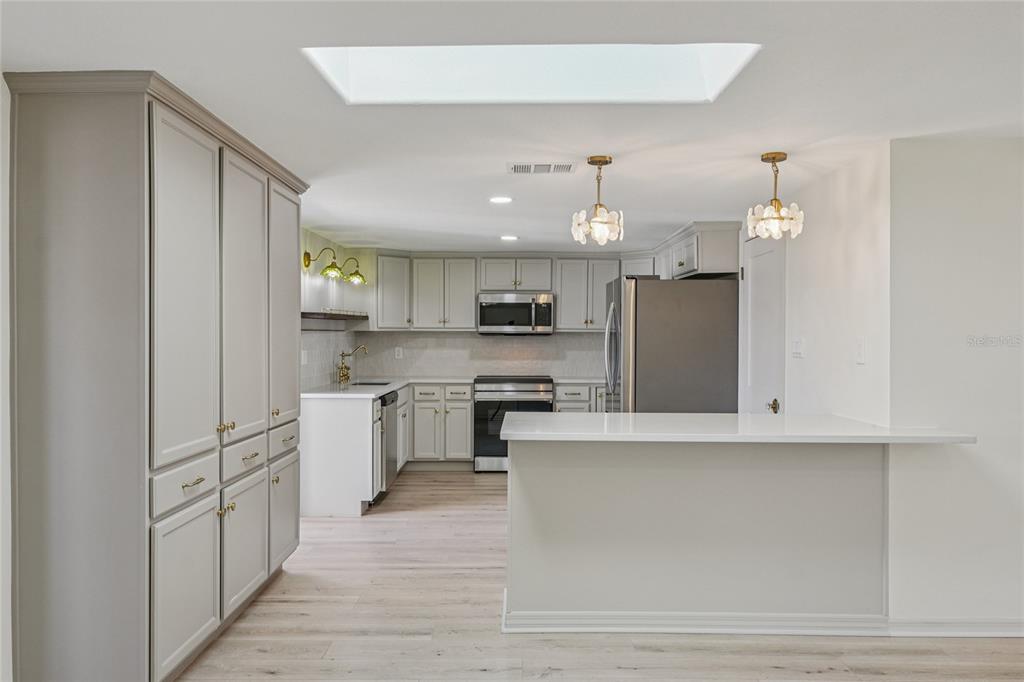 5753 10th Avenue New Port Richey, FL 34652 - Photo 15 of 46 a kitchen with white cabinets and stainless steel appliances