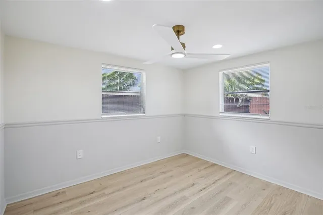 an empty room with wooden floor and window