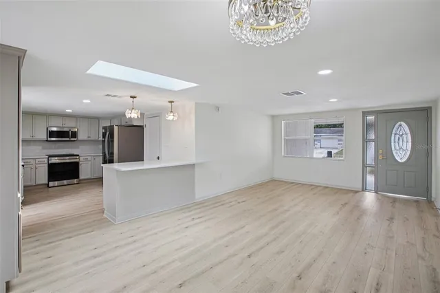a view of a kitchen with a sink a refrigerator and a stove top oven
