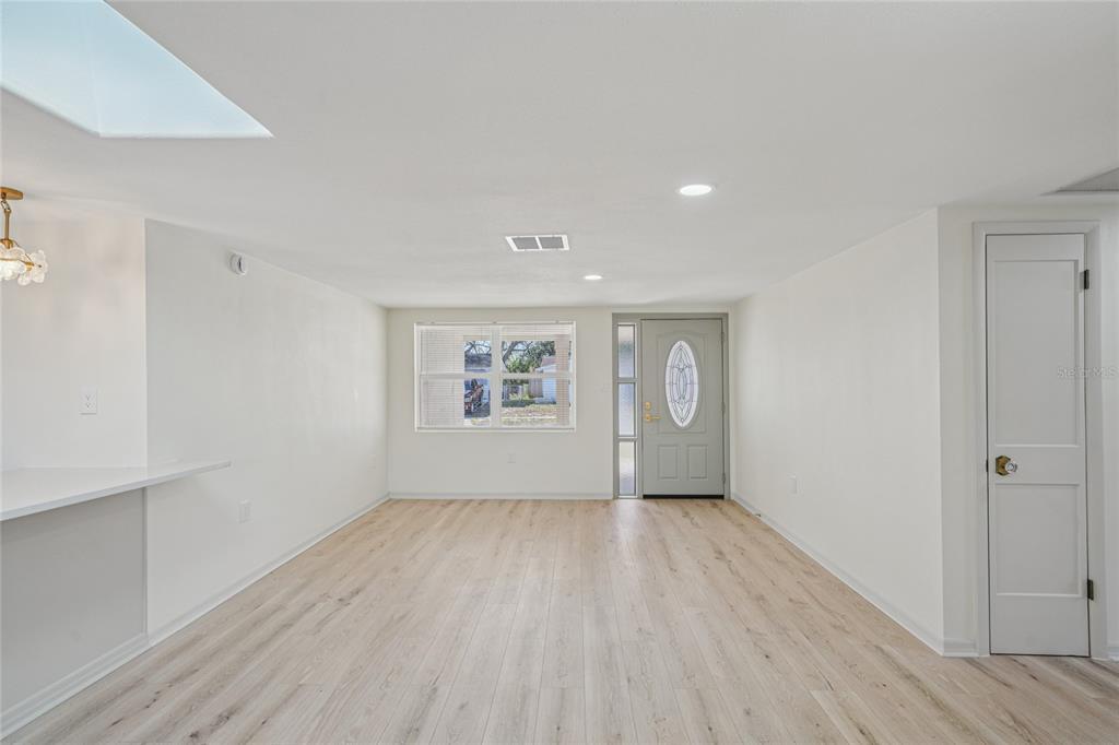 5753 10th Avenue New Port Richey, FL 34652 - Photo 9 of 46 a view of an empty room with wooden floor and a window