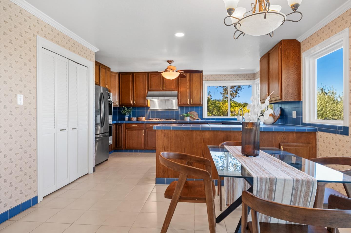 681 Upland Road Redwood City, CA 94062 - Photo 21 of 85 a kitchen with stainless steel appliances granite countertop a sink dishwasher a stove a refrigerator with a dining table and chairs