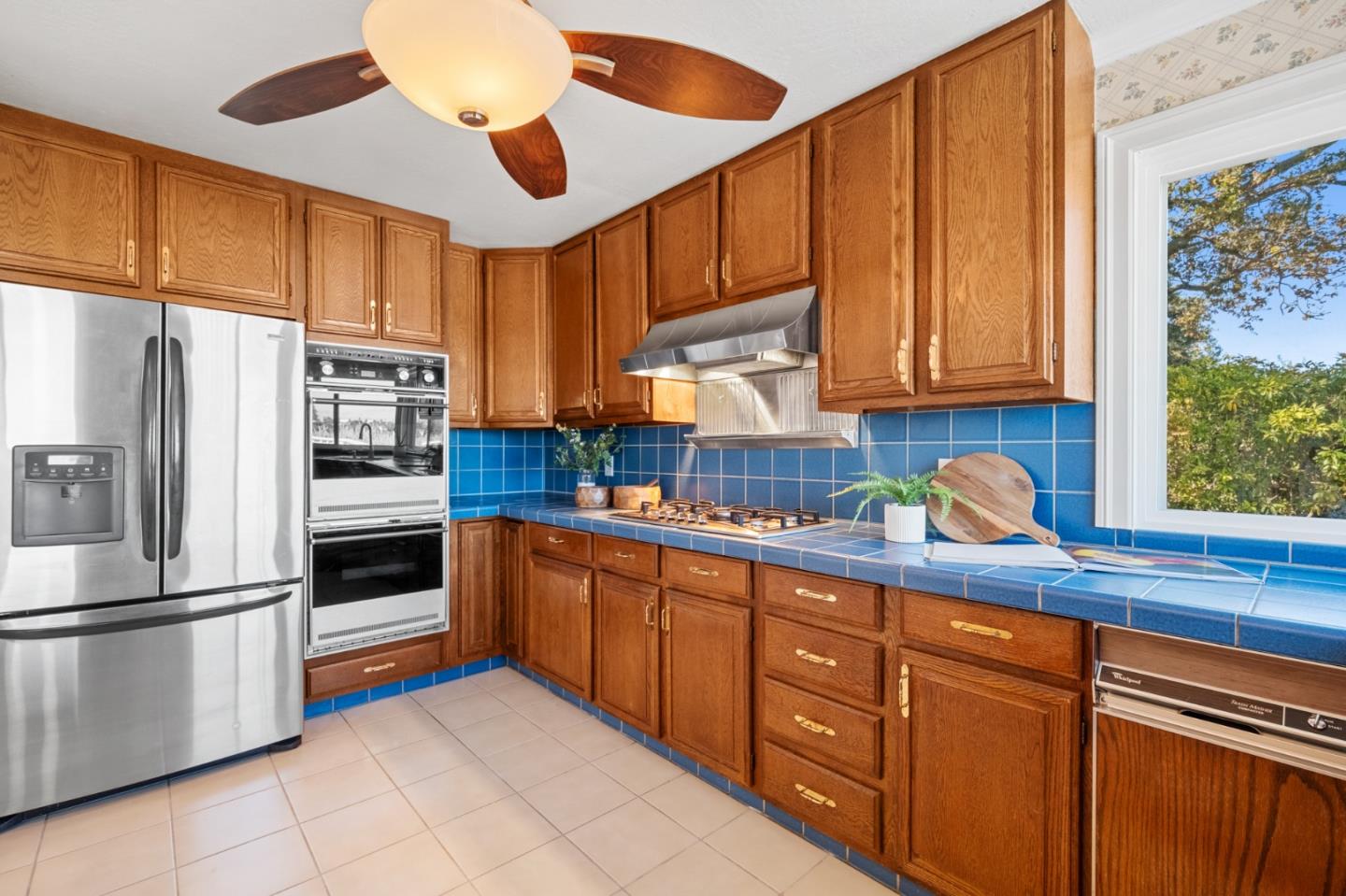 681 Upland Road Redwood City, CA 94062 - Photo 23 of 85 a kitchen with stainless steel appliances granite countertop a refrigerator a sink dishwasher a stove and white countertops with wooden floor