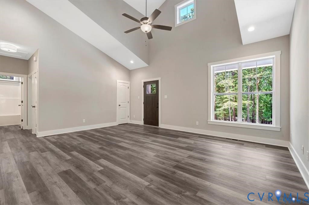 227 Oak Run Clarksville, VA 23927 - Photo 5 of 12 an empty room with wooden floor chandelier fan and windows