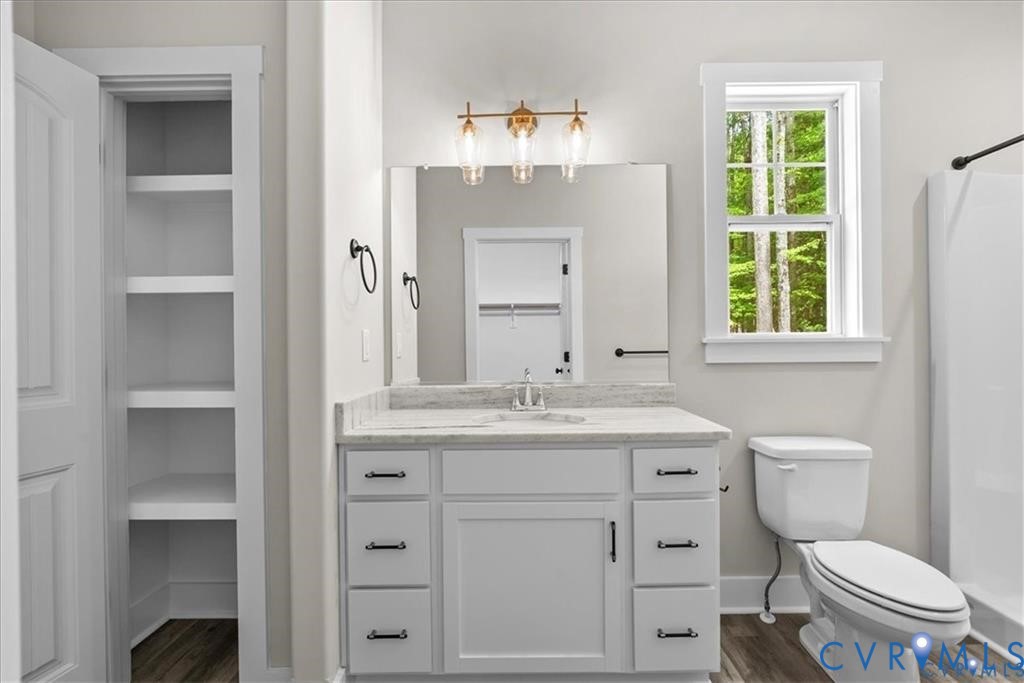227 Oak Run Clarksville, VA 23927 - Photo 8 of 12 a bathroom with a granite countertop toilet a sink and a window