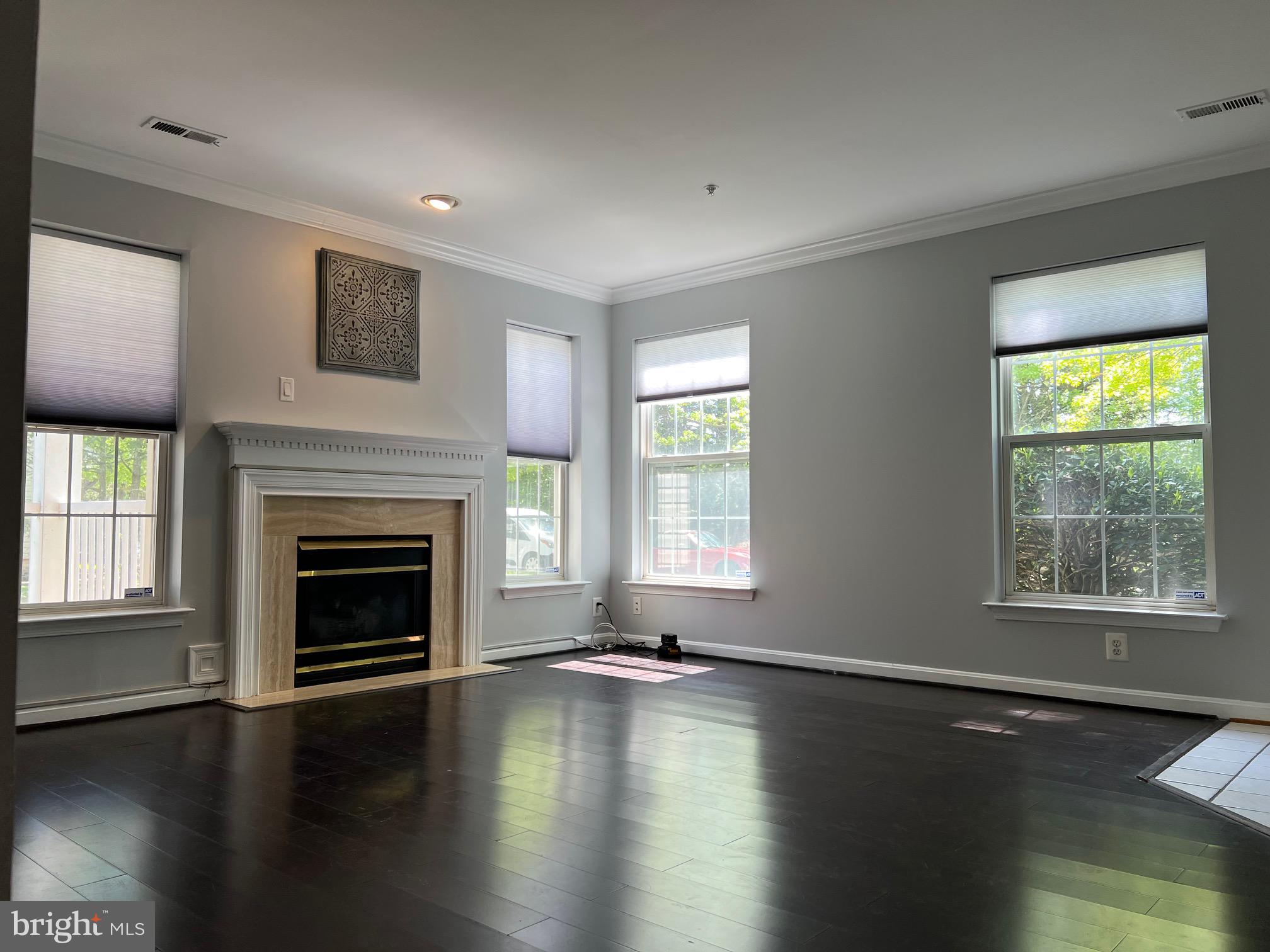 13001 Bridger Drive, Unit 1514 Germantown, MD 20874 - Photo 2 of 15 a view of a livingroom with wooden floor a fireplace and windows