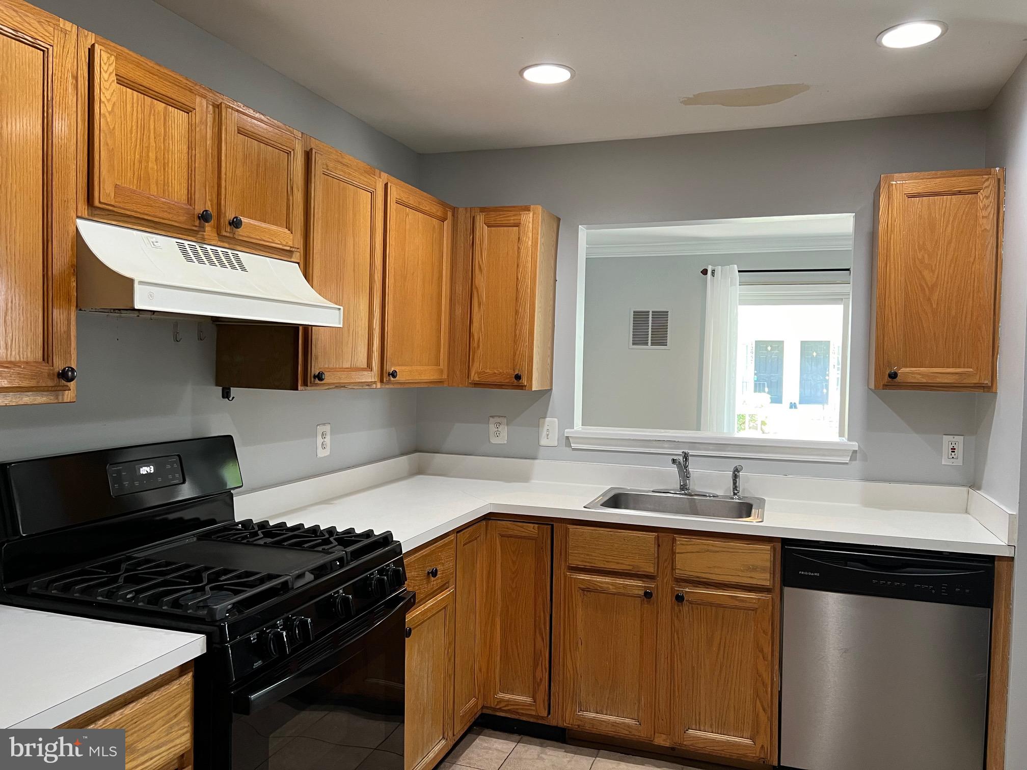 13001 Bridger Drive, Unit 1514 Germantown, MD 20874 - Photo 5 of 15 a kitchen with granite countertop a sink stove and cabinets