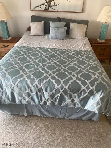 a large bed sitting in a bedroom next to a lamp