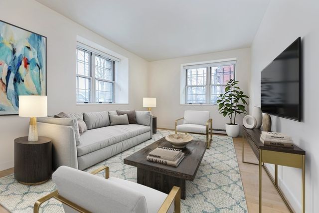 a living room with furniture a flat screen tv and a window