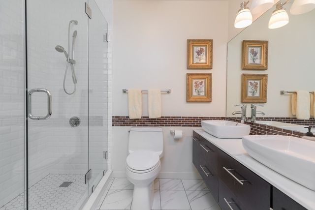 a bathroom with a granite countertop sink a toilet and shower