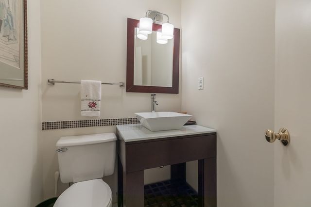 a bathroom with a toilet sink vanity and mirror