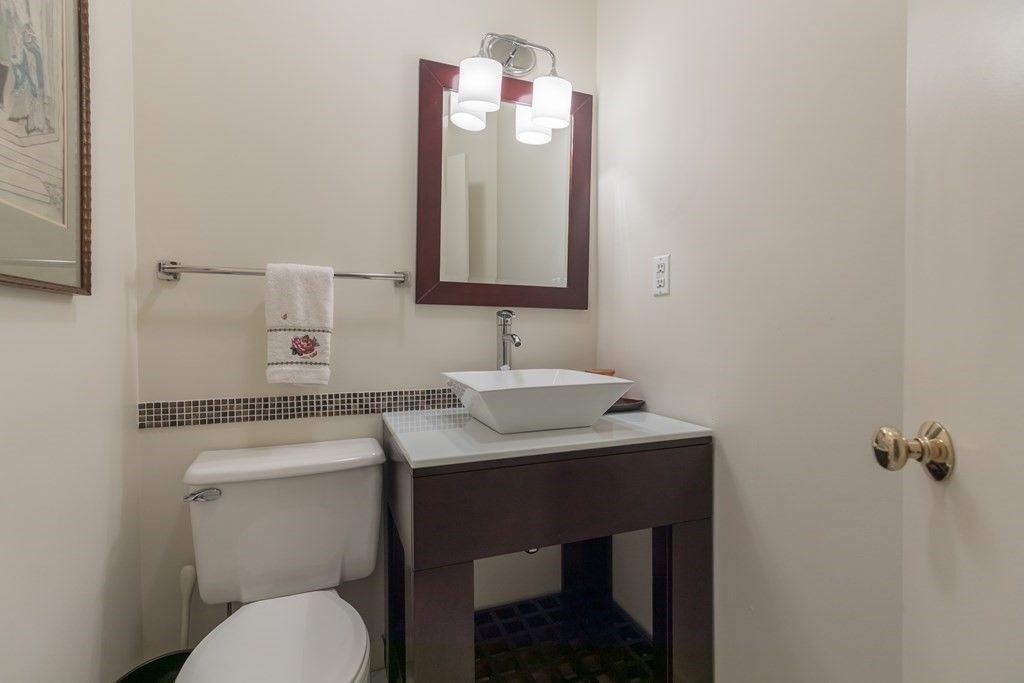 30 Monument Square, Unit 107 Boston, MA 02129 - Photo 8 of 11 a bathroom with a toilet sink vanity and mirror