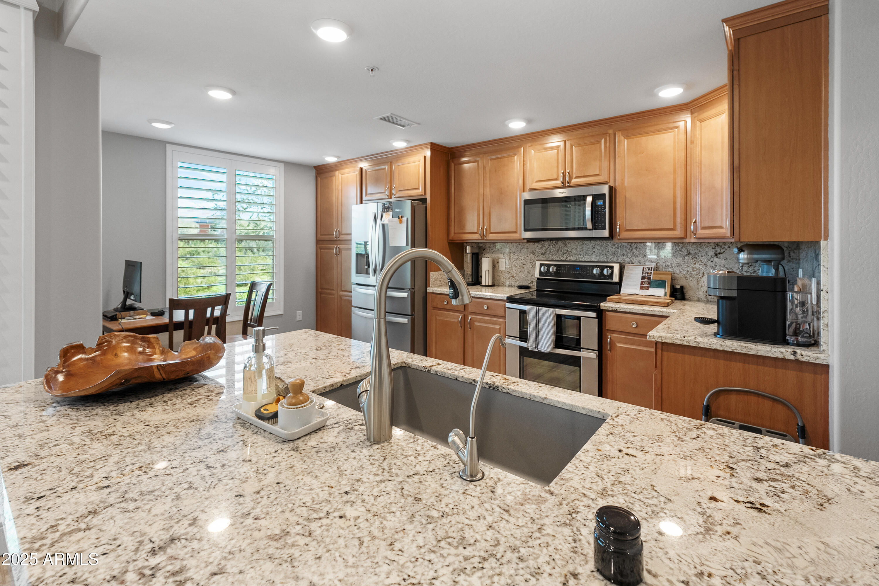 2425 West Bronco Butte Trail, Unit 1014 Phoenix, AZ 85085 - Photo 12 of 23 a kitchen with stainless steel appliances kitchen island granite countertop a stove a sink a microwave a refrigerator and cabinets