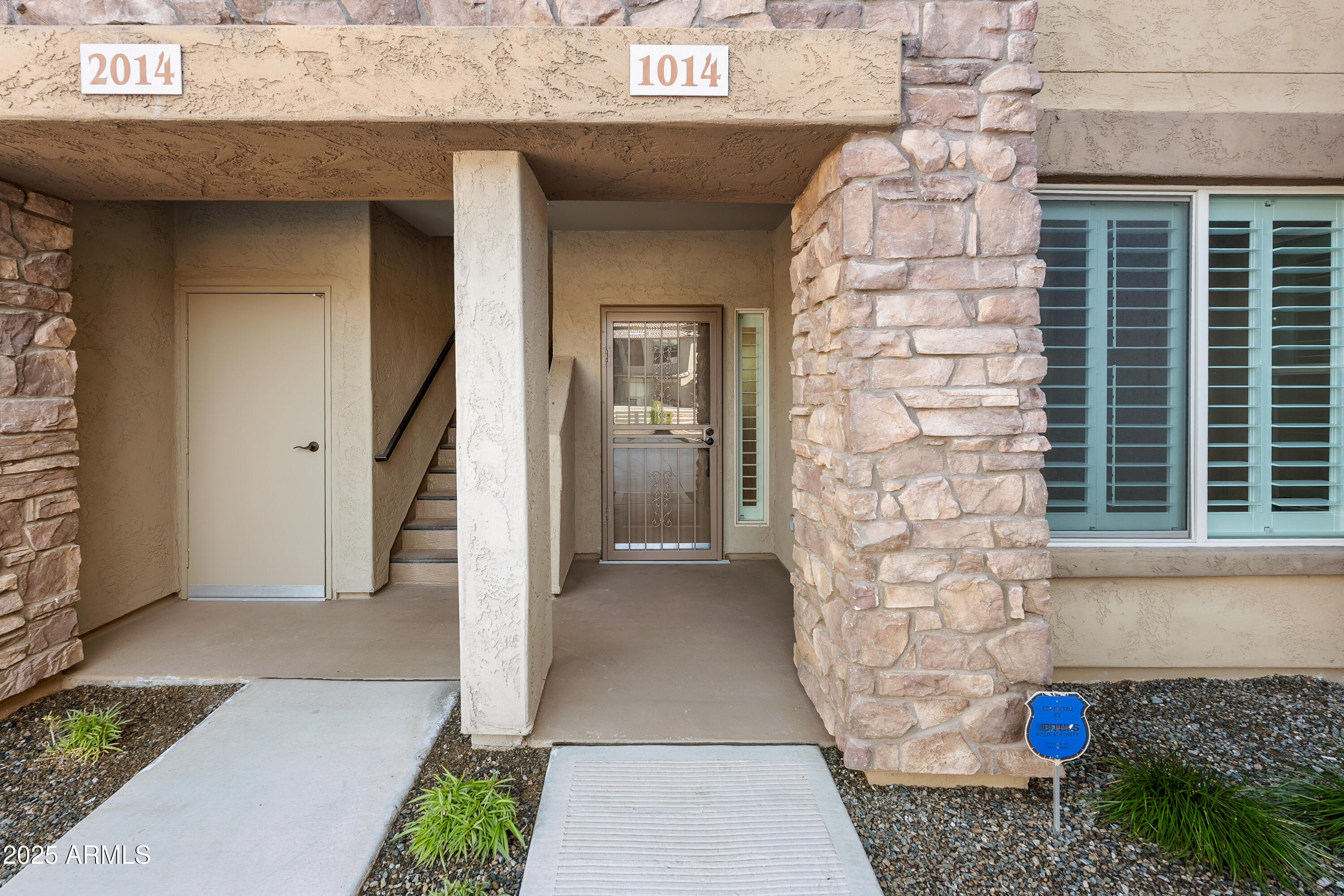 2425 West Bronco Butte Trail, Unit 1014 Phoenix, AZ 85085 - Photo 19 of 23 a view of a brick house with potted plants