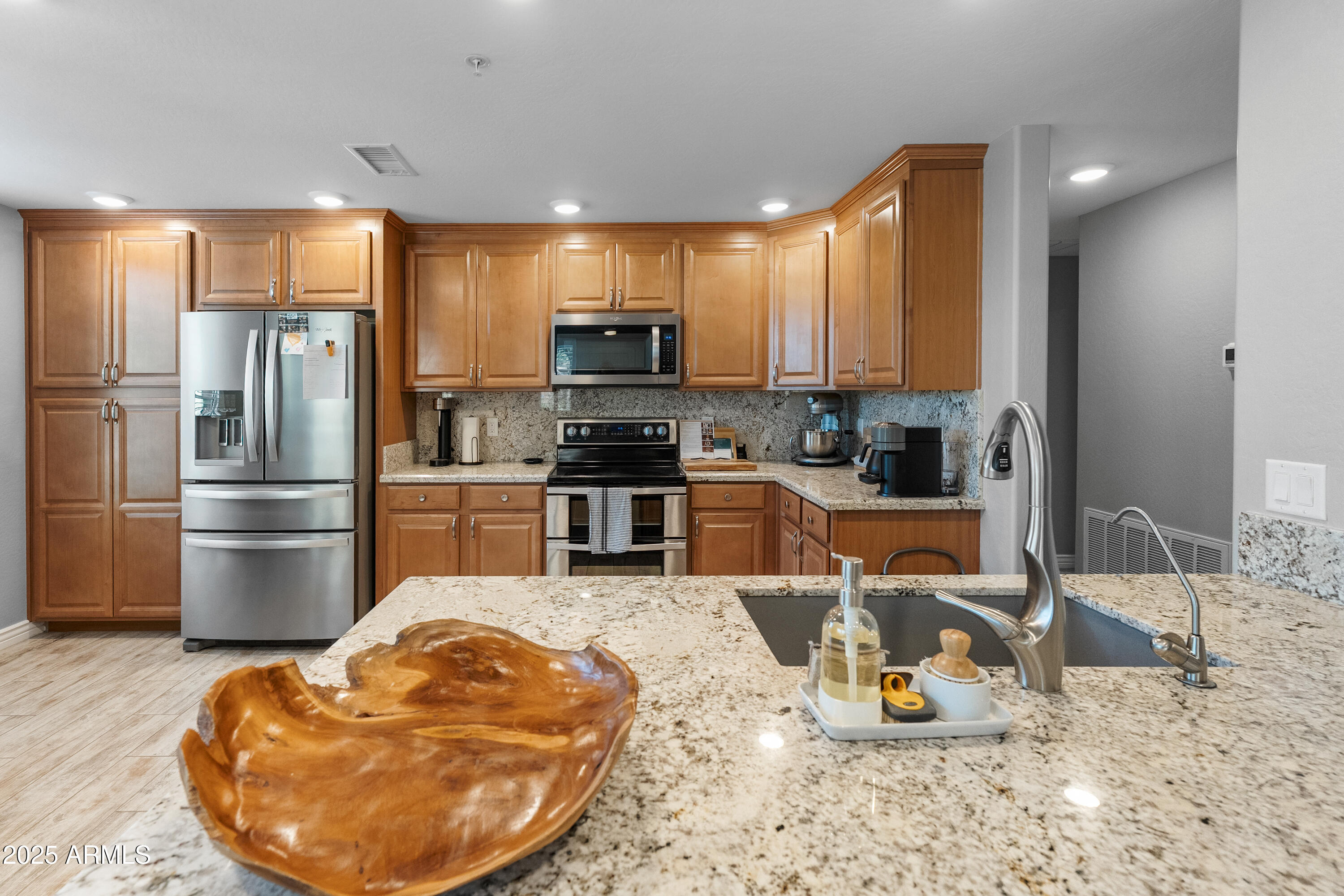 2425 West Bronco Butte Trail, Unit 1014 Phoenix, AZ 85085 - Photo 2 of 23 a kitchen with stainless steel appliances kitchen island granite countertop a refrigerator a stove a sink a dining table and chairs