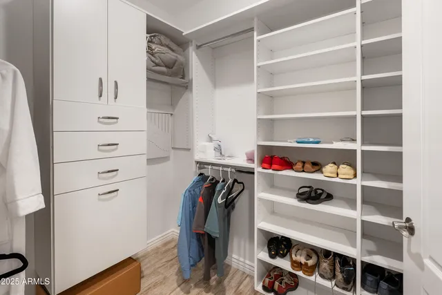 a view of walk in closet with clothes and shoes