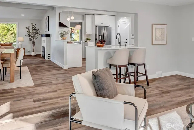 a living room with furniture wooden floor and a large window