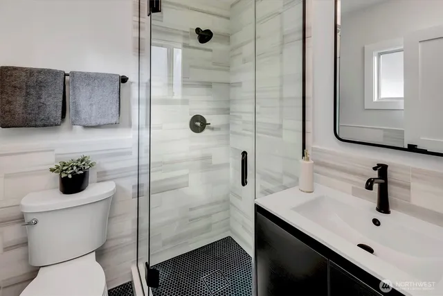 a bathroom with a sink a toilet and shower