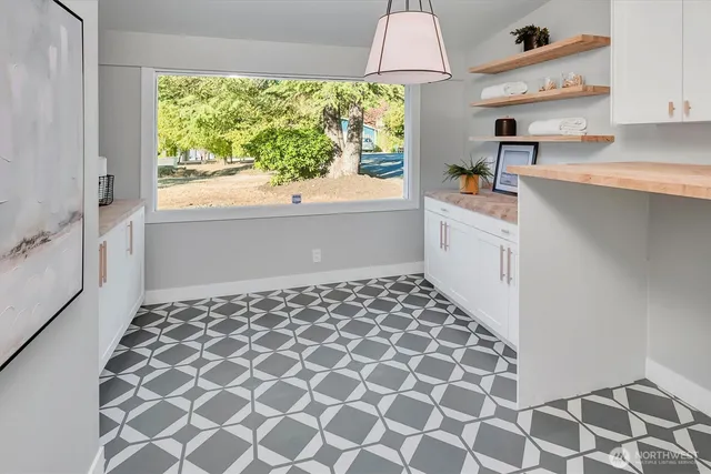 a kitchen with a sink a stove a window and cabinets