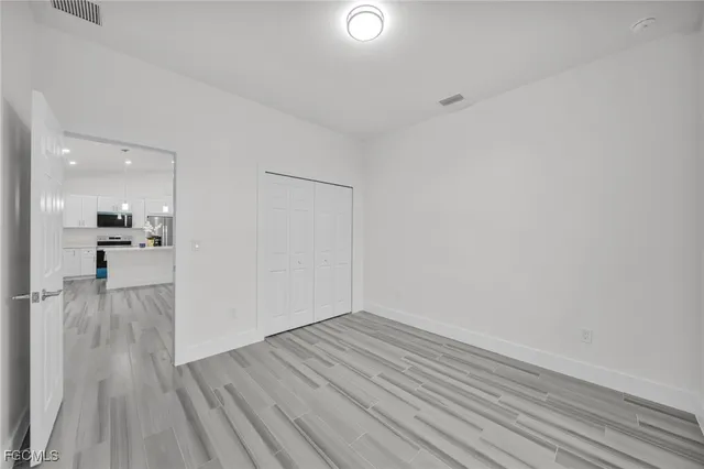 a view of a room with wooden floor and a kitchen view