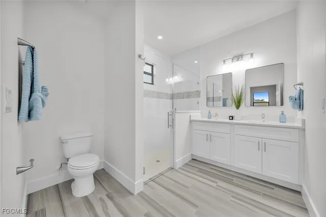 a bathroom with a sink a toilet and a large mirror