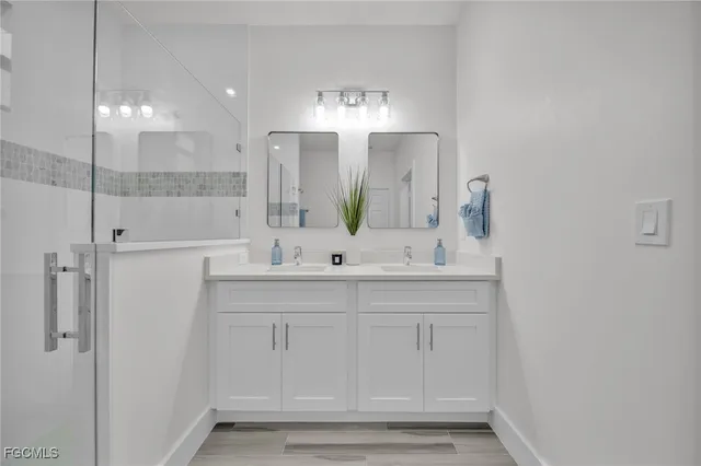a bathroom with double vanity sink and a mirror