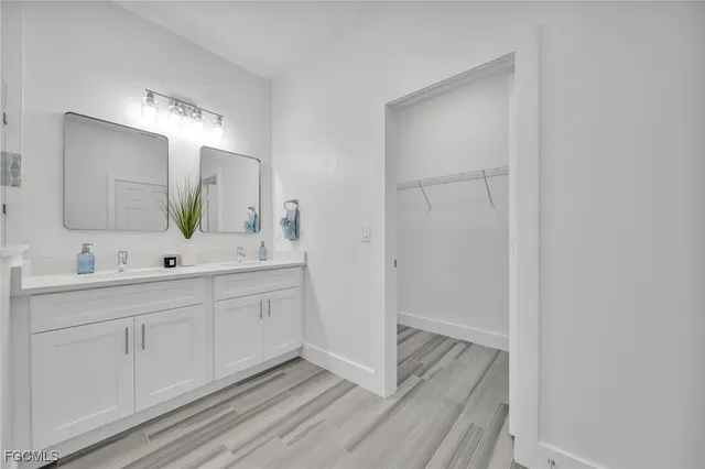 a bathroom with double vanity sink and a mirror