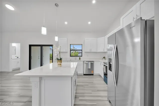 a kitchen with stainless steel appliances a refrigerator and a stove top oven