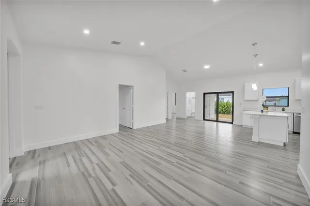 a view of empty room with wooden floor and windows