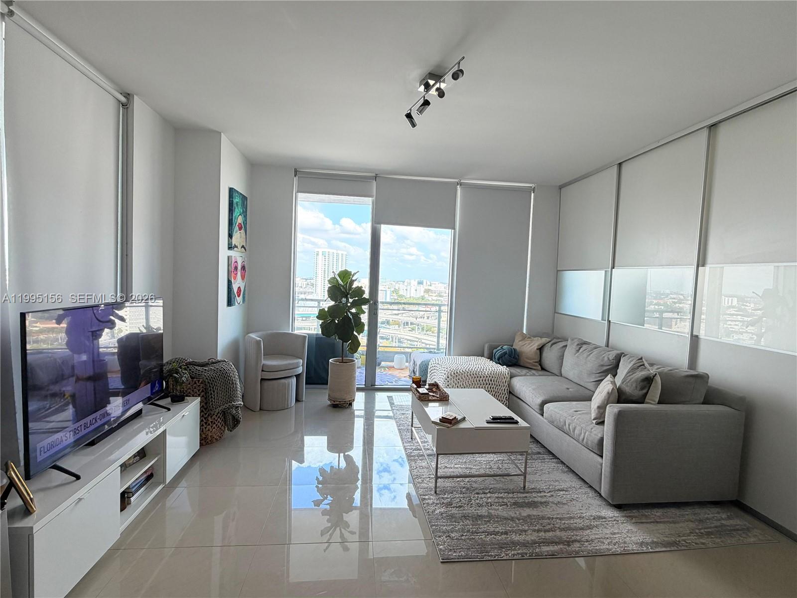 90 Southwest 3rd Street, Unit 2112 Miami, FL 33130 - Photo 8 of 40 a living room with furniture and a flat screen tv