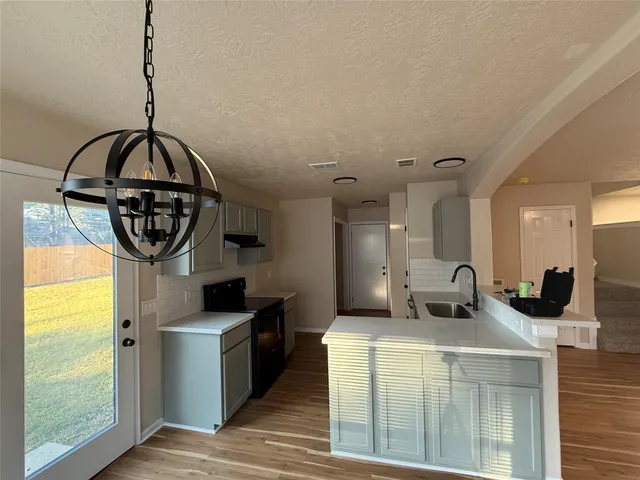 a kitchen with sink a refrigerator and a window