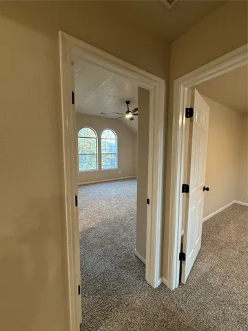 a view of a hallway with wooden floor and front door