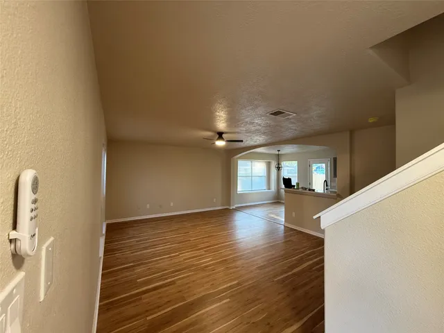a view of empty room with wooden floor