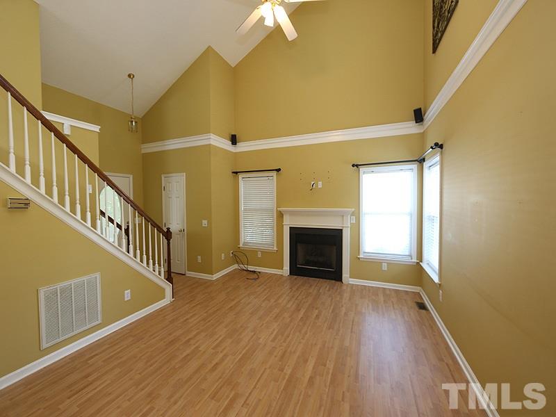4405 Moss Spring Drive Raleigh, NC 27616 - Photo 2 of 12 a view of an empty room with wooden floor a fireplace and a window