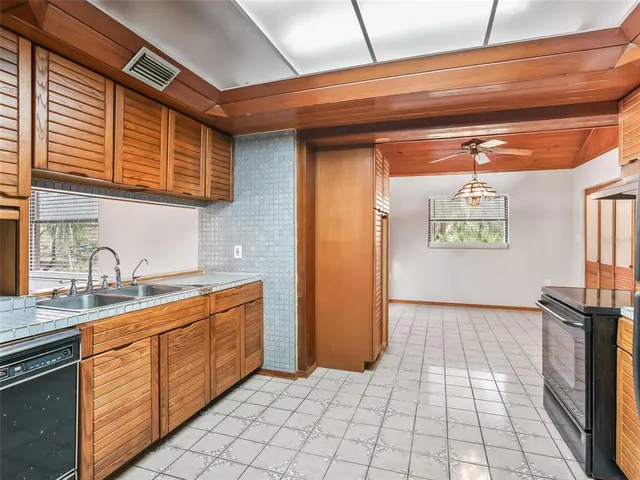 a kitchen with stainless steel appliances granite countertop a refrigerator a stove and a sink with cabinets