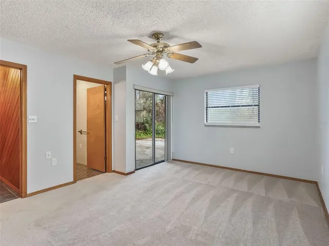 an empty room with closet and a chandelier fan